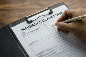 cropped-hand-writing-insurance-paper