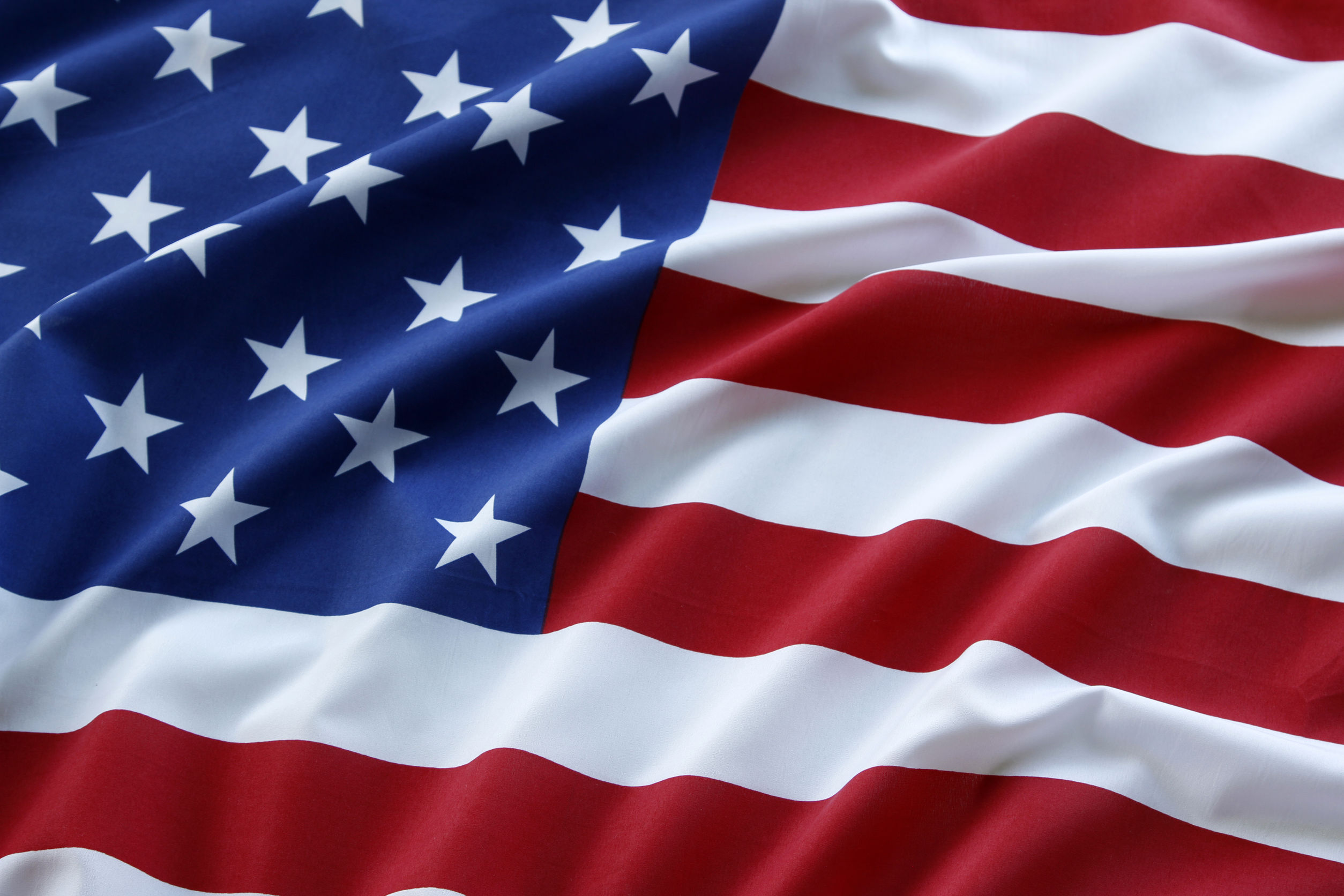 Close-up of a folded United States flag showing white stars and red, white, and blue fabric.
